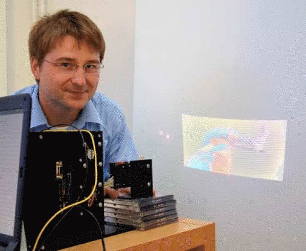 Thomas von Wantoch, wissenschaftlicher Mitarbeiter an der Technischen Fakultät der Uni Kiel, projiziert ein Bild mittels Laser und Mikrospiegel an die Wand. Das System könnte zukünftig in der Medizintechnik und Automobilindustrie eingesetzt werden. (Foto/Copyright: Denis Schimmelpfennig/CAU)
