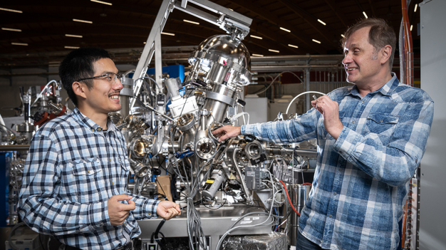 Tianlun Yu (links) und Vladimir Strocov an der ADRESS-Strahllinie der Synchrotron Lichtquelle Schweiz SLS, an der sie die Schichtstruktur aus dem Halbleiter Galliumnitrid und dem Supraleiter Niobnitrid vermessen haben. (Foto: Paul Scherrer Institut/Mahir Dzambegovic) / Tianlun Yu (left) and Vladimir Strocov at the ADRESS beamline of the Synchrotron Light Source, where they measured the layered structure made of the semiconductor gallium nitride and the superconductor niobium nitride. (Photo: Paul Scherrer Institute/Mahir Dzambegovic)