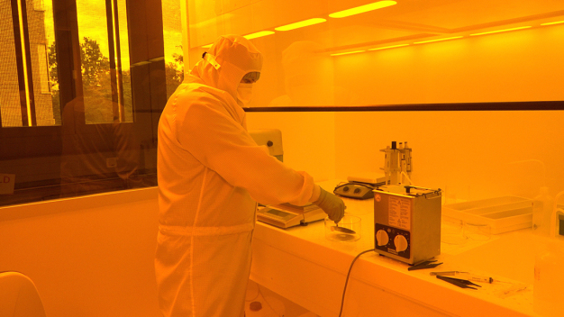 Elektrotechnikstudent Matthias Wagner taucht im Reinraum den Siliziumwafer in ein Entwicklungsbad. Elektrotechnikstudent Matthias Wagner taucht im Reinraum den Siliziumwafer in ein Entwicklungsbad.
