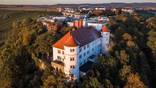 Heute zeigt sich Hohenstein am Stammsitz in
Bönnigheim mit Schloss und modernen
Gebäudekomplexen als vielseitiger Dienstleister. ©
Hohenstein / Today, at its headquarters in Bönnigheim, Germany, Hohenstein has expanded as a versatile service provider beyond the castle with modern lab buildings. © Hohenstein
