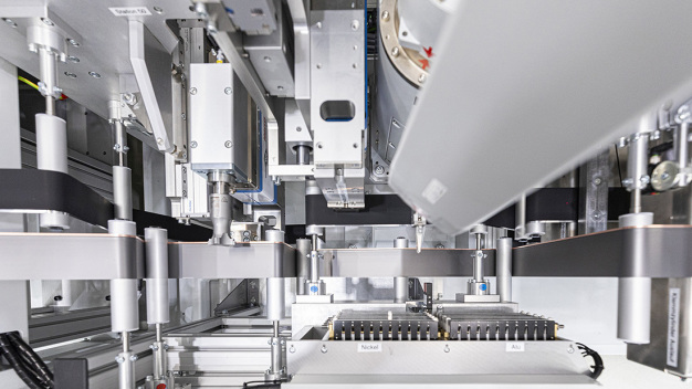 Für die Kontaktierung mit geschweißten Stromableitern legt ein Roboter die Tabs auf die Anode und Kathode, die anschließend durch Ultraschallschweißen verbunden werden. (Bildquelle: Fraunhofer IPA/Foto: Rainer Bez) / For contacting with welded current collectors, a robot places the tabs on the anode and cathode and joins them using an ultrasonic welding device. (Photo credit: Fraunhofer IPA/ photo: Rainer Bez) Für die Kontaktierung mit geschweißten Stromableitern legt ein Roboter die Tabs auf die Anode und Kathode, die anschließend durch Ultraschallschweißen verbunden werden. (Bildquelle: Fraunhofer IPA/Foto: Rainer Bez) / For contacting with welded current collectors, a robot places the tabs on the anode and cathode and joins them using an ultrasonic welding device. (Photo credit: Fraunhofer IPA/ photo: Rainer Bez)