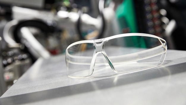 Uvex-Schutzbrille im aktuellen Design, wie sie „ready to use“ aus der Spritzgießmaschine kommt. Die Brillen werden in Deutschland und der Schweiz über offizielle Stellen an Pflege- und medizinisches Personal verteilt. (Foto: ARBURG) / Uvex protective goggles in the latest design, as they come ready to use from the injection moulding machine. The goggles are distributed to care and medical personnel in Germany and Switzerland via official channels. (Photo: ARBURG)