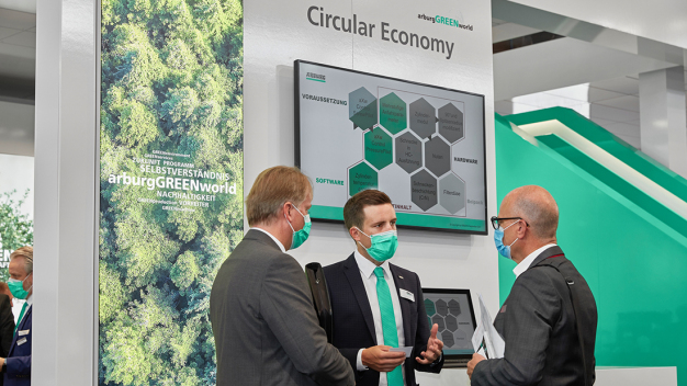 Expertenwissen pur: Bertram Stern (Mitte), Sustainability Manager bei Arburg, und Werner Faulhaber (l.), Arburg-Bereichsleiter Entwicklung, erläutern die verschiedenen Aspekte der „arburgGREENworld“. (Foto: ARBURG) / Sheer expertise: Bertram Stern (centre), Sustainability Manager at Arburg, and Werner Faulhaber (left) Arburg’s Director Research & Development, explain the various aspects of “arburgGREENworld”. (Photo: ARBURG)