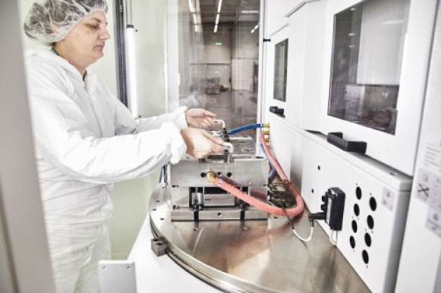 Die Spritzgussmaschine befindet sich im Schwarzbereich des neuen Produktions- und Logistikzentrums. Sie lässt sich jedoch vom Reinraum aus be- und entladen. Für den Spritzbereich wurde eine horizontal strömende Filter-Fan-Unit (FFU) an das Gehäuse der Spritzgussmaschine als Schutzzone angebaut, damit sich die Bauteile stets unter Reinraumbedingungen befinden. (Quelle: bc-technology GmbH) Die Spritzgussmaschine befindet sich im Schwarzbereich des neuen Produktions- und Logistikzentrums. Sie lässt sich jedoch vom Reinraum aus be- und entladen. Für den Spritzbereich wurde eine horizontal strömende Filter-Fan-Unit (FFU) an das Gehäuse der Spritzgussmaschine als Schutzzone angebaut, damit sich die Bauteile stets unter Reinraumbedingungen befinden. (Quelle: bc-technology GmbH)