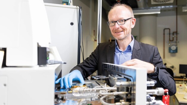 El Prof. Dr. Reitzenstein frente a la cámara de muestras del sistema de litografía por haz de electrones, que fabrica nan Estructuras de alta precisión para fuentes de luz cuántica escalables de próxima generación.
