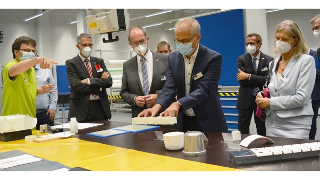 Technologie zum Anfassen: Wirtschaftsminister Tarek Al-Wazir begutachtet ein Bauteil aus dem Hightech-Werkstoff Faserverbundkeramik. / Hands-on technology: Economics Minister Tarek Al-Wazir examines a component made of the high-tech material fiber-reinforced ceramics.