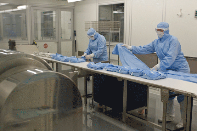 In einem Reinraum der ISO-Klasse 4 legen die Mitarbeiter von CWS-boco die gewaschene Reinraumkleidung zusammen und verpacken sie.