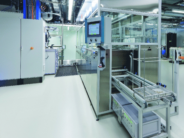 Bei der Anlage für die Endreinigung werden die Teile direkt in den Reinraum ausgegeben. Die Anlage und die Transporteinheit in den Reinraum sind vollständig gekapselt. / The final cleaning system delivers the product directly into the cleanroom. The system and its conveyor unit are fully enclosed all the way into the cleanroom. 