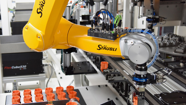 Die Montage von fünf Millionen Hochvolt-Steckern jährlich für Elektro- und Hybridfahrzeuge stellt hohe Ansprüche an die Automation. Bei der Eberhard AG übernimmt einer der insgesamt sechs verbauten TX2-60L von Stäubli das Einlegen eines Steckergehäuses in den Werkstückträger. (Copyright: Stäubli Tec-Systems GmbH Robotics)