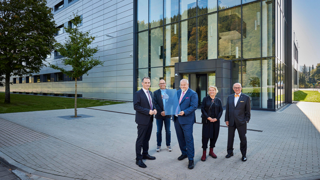 Matthias Altendorf übergibt Dr. Peter Selders vor dem neuen Gebäude eine Kachel aus Schmelzglas, aus der das neue Wandbild „Global Player“ gefertigt ist. Auf dem Bild (von links): Dr. Peter Selders, Geschäftsführer von Endress+Hauser Level+Pressure in Maulburg, Architekt Thomas Duttlinger, Matthias Altendorf, CEO der Endress+Hauser Gruppe, Künstlerin Britta Schmidhauser und Dr. h.c. Klaus Endress, Verwaltungsratspräsident der Endress+Hauser Gruppe. / Matthias Altendorf hands over a rectangle made of fused glass to Dr Peter Selders in front of the new building, from which the new mural “Global Player” is made. On the picture (from left): Dr Peter Selders, Managing Director of Endress+Hauser Level+Pressure in Maulburg, architect Thomas Duttlinger, Matthias Altendorf, CEO of the Endress+Hauser Group, artist Britta Schmidhauser and Dr Klaus Endress, President of the Supervisory Board of the Endress+Hauser Group. 