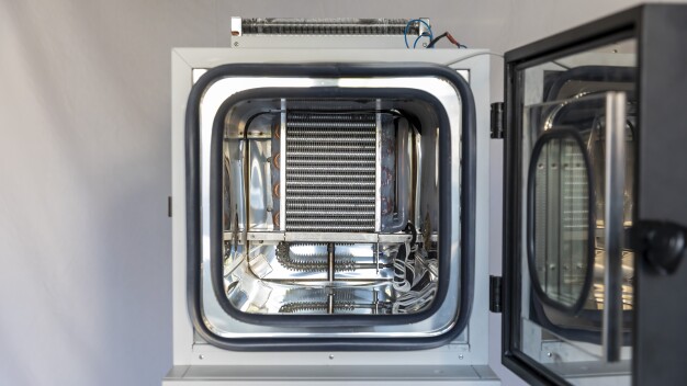 Chambre d'essai climatique avec porte ouverte – salle d'essai en acier inoxydable, évaporateur à ailettes et éléments chauffants sur le mur arrière de la chambre. © FDM Environment Makers