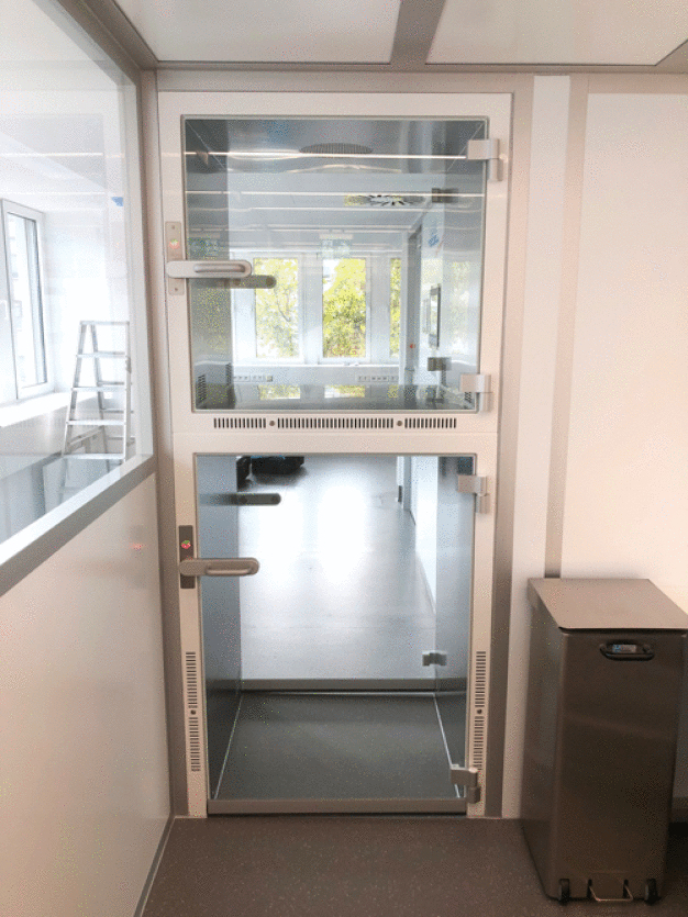 Über bodentiefe Materialschleusen werden Materialwägen sicher in den Reinraum eingeschleust. / The 100-square-metre cleanroom laboratory was planned especially for the cramped spaces and achieves cleanroom class GMP B.