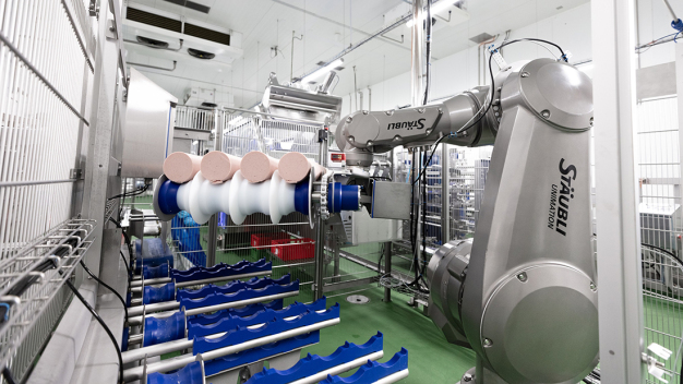 Der TX200 bringt die Wurstkaliber sicher und schonend zur Beladeseite des Slicers. (Copyright: Stäubli Tec-Systems GmbH Robotics) / The TX200 reliably and carefully conveys the sausages to the loading side of the slicer. (Copyright: Stäubli Tec-Systems GmbH Robotics)