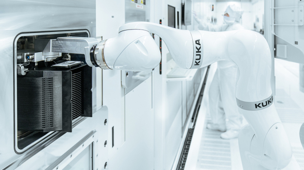 Millimetergenau legt der KUKA Roboter die Siliziumwafer in die Bearbeitungskammer. / The KUKA robot places the silicon wafers into the processing chamber with millimeter precision.