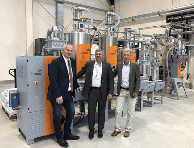 Vlnr Thomas Luger, Knut Hilgert (motan holding) und Horst Bar vor der motan Anlage in der LIT Factory. / Left to right: Thomas Luger (Luger GesmbH), Knut Hilgert (motan holding) and Horst Bar (Luger GesmbH) in front of a motan system at the LIT Factory in Linz.