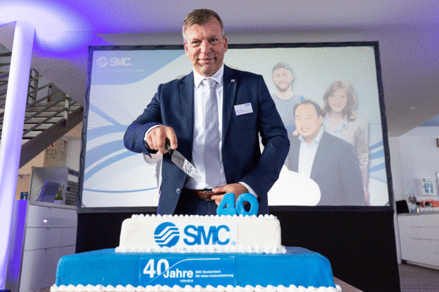 Ralf Laber, Geschäftsführer SMC Deutschland, schneidet beherzt die Geburtstagstorte an. (Foto: SMC Deutschland GmbH)