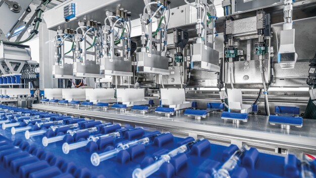 Die Spritzen gelangen über das Transportsystem zu den aufgerichteten Schachteln (Hintergrund). (Foto: Gerhard Schubert GmbH)