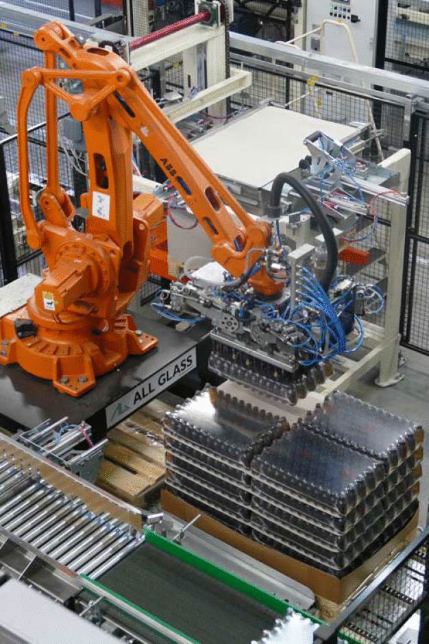 Der Roboterarmlegt ein Safe Pack auf der Palette ab. / The robot arm puts a layer of shrink wrapped bottles on the pallet.