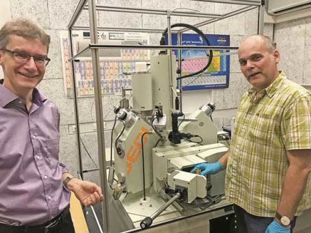 ZELMI-Leiter Dr.-Ing. Dirk Berger (l.) und Dipl.-Ing. Jörg Nissen bereiten an der Feldemissions-Elektronenstahlmikrosonde eine Messung vor. Der umgebende Magnetfeldrahmen verhindert Störungen, die den Elekronenstrahl ablenken und das Ergebnis verfälschen könnten. (© TU Berlin/PR/Patricia Pätzold)