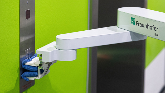 By using its flexible cleaning tool, DeKonBot can disinfect different objects by wiping, including elevator buttons. (© Fraunhofer IPA/Photo: Rainer Bez) By using its flexible cleaning tool, DeKonBot can disinfect different objects by wiping, including elevator buttons. (© Fraunhofer IPA/Photo: Rainer Bez)