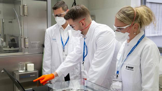 Die Spezialisten der BASF und Kilian analysieren gemeinsam die Ergebnisse der Pressversuche im Labor. (Bildnachweis:Romaco Group) / Specialists from BASF and Kilian get together to analyze the results of the compression tests in the lab. (Photo: Romaco Group) 