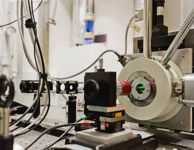 Der Quantenpunkt - eine Art künstliches Atom - wird in einem Kryostaten auf eine Temperatur nahe des absoluten Nullpunktes gekühlt. Durch einen Laser werden Photonen-Zwillinge erzeugt und mit einem Mikroskopobjektiv eingesammelt. (© Oana Popa/PR/TU Berlin)