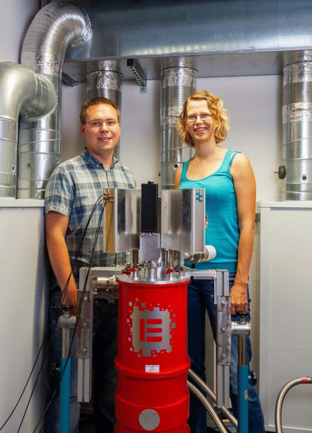 Elisabeth Schlottmann und Marco Schmidt, beide wissenschaftliche Mitarbeiter von Prof. Reitzenstein an der TU Berlin, präsentieren den komplexen Aufbau des speziellen Photonendetektors. (© TU Berlin/PR/Felix Noak)