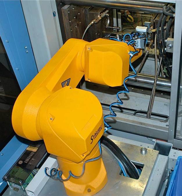 Bei Bürkert Fluid Control Systems bewährt sich ein kompakter Stäubli Sechsachser seit vielen Jahren. Hier wird eine Kunststoff-Komponente für einen Prozessantrieb gespritzt und voll automatisiert unter Roboterregie montiert. / For many years now, a compact Stäubli six-axis robot has performed sterling work at Bürkert Fluid Control Systems. Plastic drive components are injection-moulded and assembled in a fully automated process controlled by a robot.