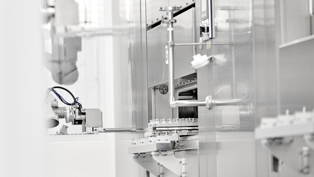 The systems are loaded on one side and unloaded on the other. This task is performed by a robot that grips the frames with vials. (Image rights: @ Vetter Pharma International GmbH)